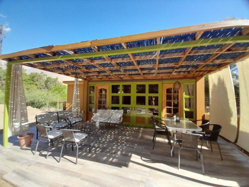 a patio with tables and chairs under a pergola at Casa Alma in Vicuña