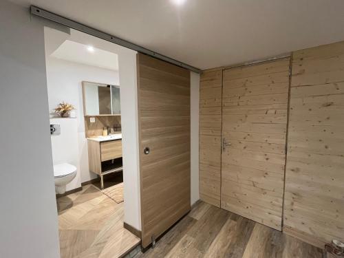 La salle de bains est pourvue de toilettes et d'un placard en bois. dans l'établissement Appartement entier, à Corps-Nuds