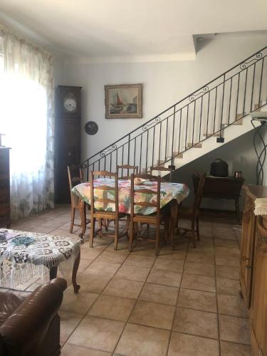 une salle à manger avec une table et un escalier dans l'établissement Maison au calme avec jardin et garage proche du centre et de la mer, à Cannes
