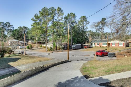 a street with a red car parked in a driveway at 6 Mi to The Masters Updated Home with Yard! in Augusta