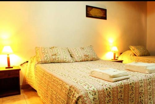 a bedroom with a bed with two lamps and two beds at Litoral Apart in Eldorado