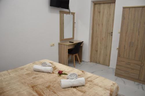 a bedroom with a bed and a mirror and a desk at Kourites Apartments in Zarós