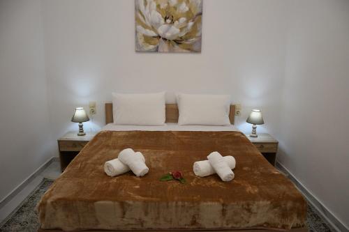 a bedroom with a bed with two towels on it at Kourites Apartments in Zarós
