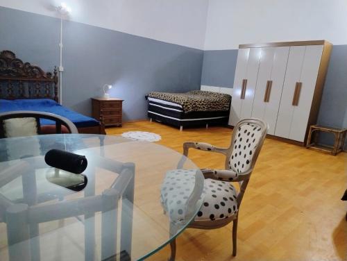 a room with a glass table and chairs and a bed at Casa loft Internet 500Mb in Sao Paulo