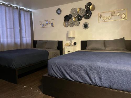 two beds in a room with plates on the wall at The Village Inn Hotel in Milwaukee
