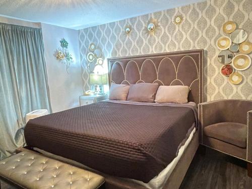 a bedroom with a large bed and a chair at The Village Inn Hotel in Milwaukee