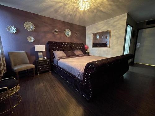 a bedroom with a large bed and a chair at The Village Inn Hotel in Milwaukee
