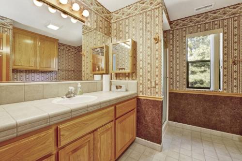 un baño con lavabo y espejo en Eagle Point Lake House by Big Bear Vacations, en Big Bear Lake