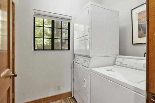 a kitchen with white appliances and a window at Serenity Cove Lake House by Big Bear Vacations in Big Bear Lake