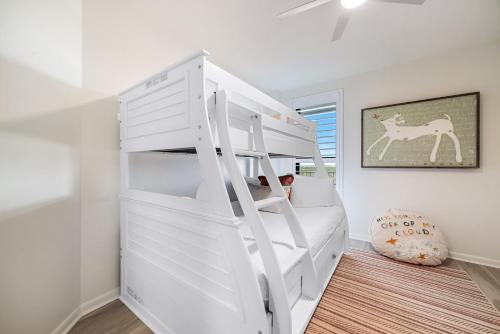 a white bunk bed in a white room with a ladder at Summer House Unit 904B in Orange Beach