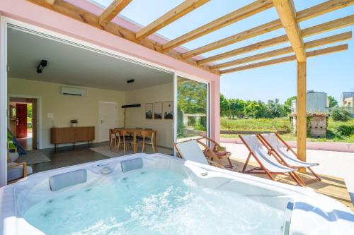 a jacuzzi tub in a living room with chairs at Bacelos pink house - riverfront with jacuzzi in Soure