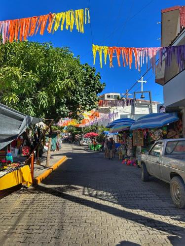 a street with a market with a car on it at Iglú Sparrow vista al cielo in Barra de Navidad