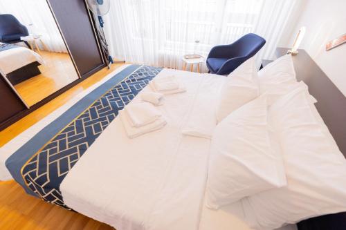 a bed with white sheets and a blue chair in a room at Retro house in Kamnik in Kamnik