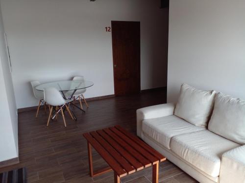 a living room with a white couch and a table at TORRE YAX-CHE URBAN CENTER in Cancún