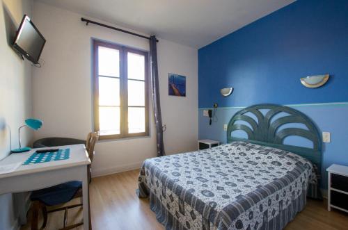 Hôtel du Commerce في ميلو: غرفة نوم زرقاء مع سرير ومكتب