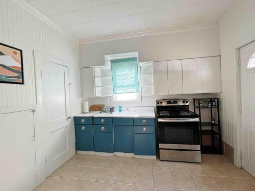a kitchen with blue cabinets and a stove top oven at Southern Comfort Oasis in Beaumont
