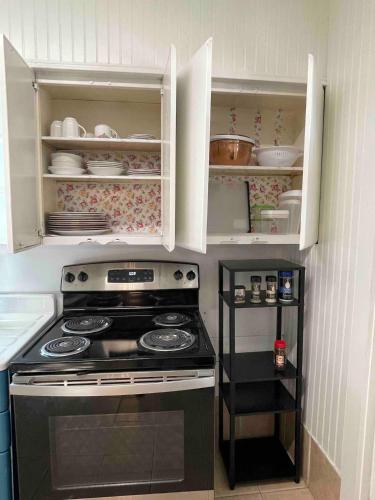 a kitchen with a stove and white cabinets at Southern Comfort Oasis in Beaumont