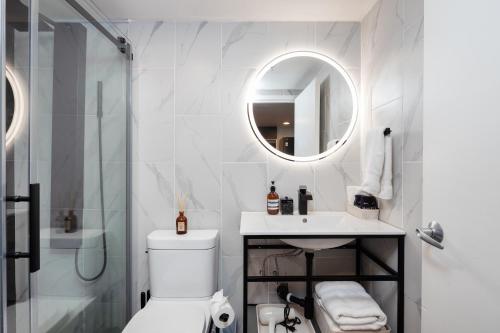 a bathroom with a toilet and a sink and a mirror at Loft in Entertainment District with FREE underground Parking in Vancouver