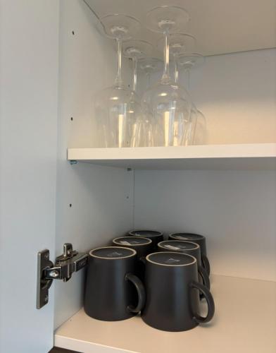 a row of pots and pans sitting on a shelf at Nisay Home, Apart Suite, N5 in Ludwigsburg