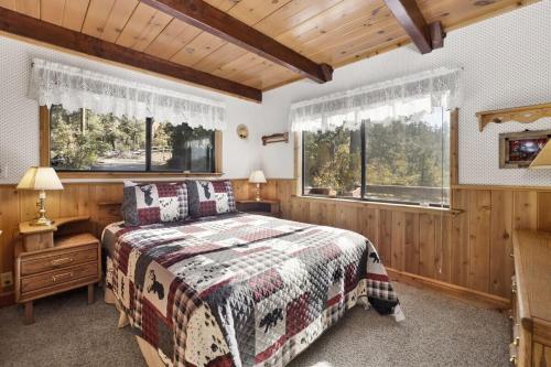 a bedroom with a bed and two windows at Highland Oaks Retreat by Big Bear Vacations in Sugarloaf