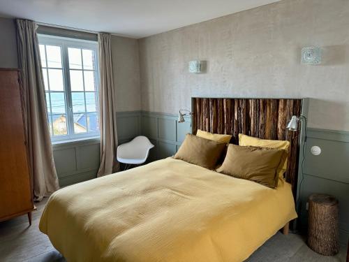 une chambre avec un grand lit et une fenêtre dans l'établissement -LA CORDIALITÉ-, à Ault