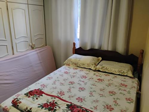 a bed with a floral quilt on it in a bedroom at Chácara Alci Guedes in São Gabriel