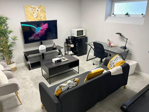 a living room with a couch and a flat screen tv at Modern Basement Suite with Comforts in Winnipeg