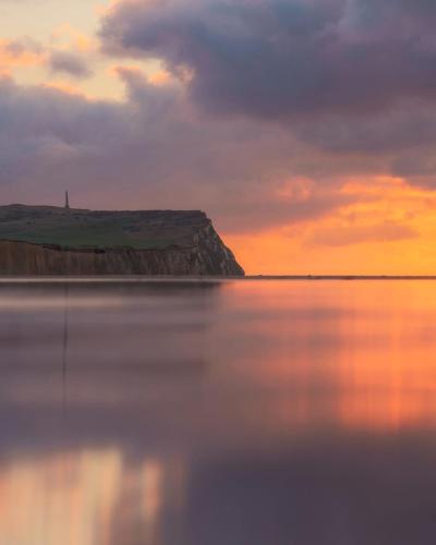 a sunset over a body of water with the sky at La maisonnette de Camillou in Calais
