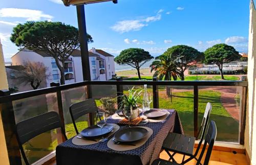 - une table sur un balcon avec vue dans l'établissement Le lac des reflets dorés - Établissement classé 3 étoiles ATOUT FRANCE, au Barcarès
