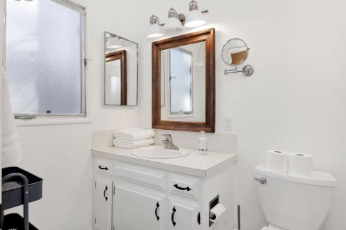 a white bathroom with a sink and a mirror at The Cottage at Shay Meadows by Big Bear Vacations in Big Bear City