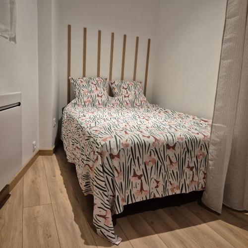 - une chambre avec un lit doté d'un couvre-lit à motifs zébrés dans l'établissement superbe studio proche centre, à Chambéry