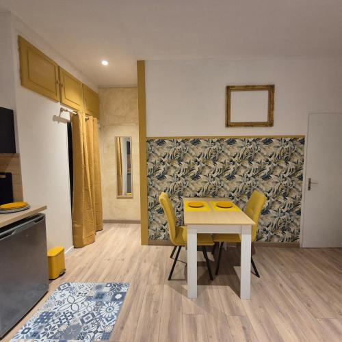 une cuisine avec une table et des chaises dans une pièce dans l'établissement superbe studio proche centre, à Chambéry