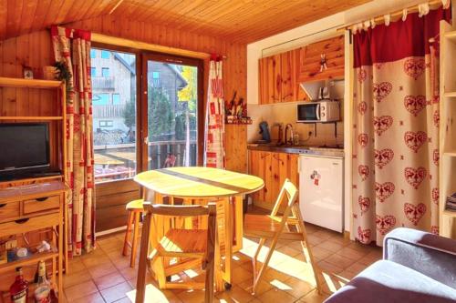 une petite cuisine avec une table et une table dans l'établissement Studio chaleureux à Thollon-les-Mémises - 20 m² avec vue, à Thollon-les-Mémises