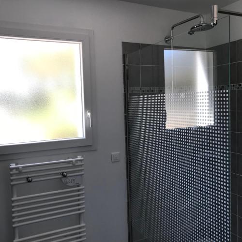 une salle de bain avec une douche en verre avec une fenêtre dans l'établissement Plain pied idéalement situé, à Sainte-Lucie de Porto-Vecchio