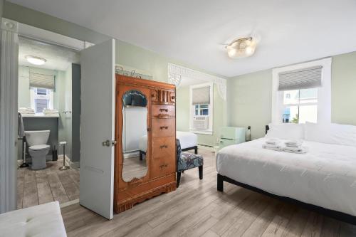 una camera con letto e comò con specchio di The Inn At Ocean Grove a Ocean Grove