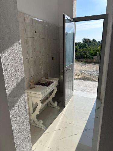 a bathroom with a sink and a glass door at Cozy Vacation Apartments in Hamallaj in Barç