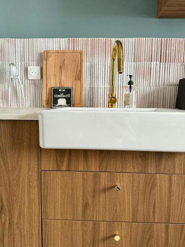 une cuisine avec un évier et un meuble en bois dans l'établissement -LA CORDIALITÉ-, à Ault