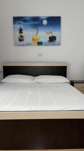 a bed in a bedroom with a picture on the wall at VILLA MARLEN in Ksamil