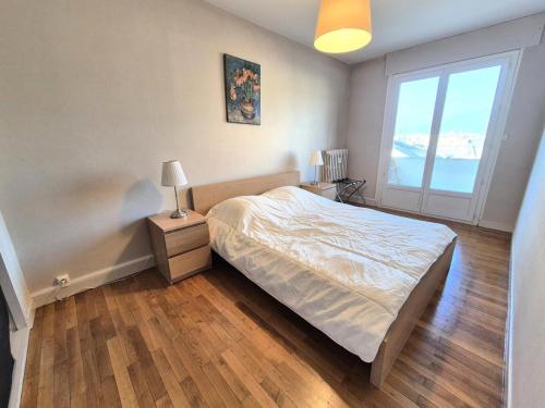 une chambre avec un lit et une grande fenêtre dans l'établissement Résidence Le Dent Du Chat - A la fois au calme et en centre ville pour cet appartement ! MAE-6554, à Aix-les-Bains