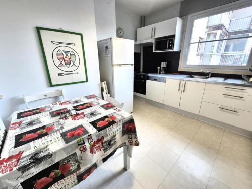 une cuisine avec une table et un réfrigérateur dans l'établissement Résidence Le Dent Du Chat - A la fois au calme et en centre ville pour cet appartement ! MAE-6554, à Aix-les-Bains