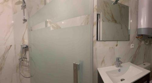 une salle de bain blanche avec un lavabo et un miroir dans l'établissement Charming Apartment Near Paris, à Vitry-sur-Seine