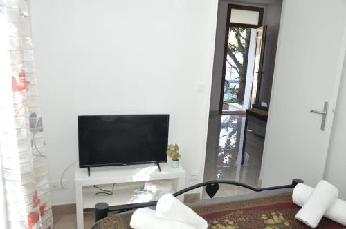 un salon avec une télévision sur une table blanche dans l'établissement Charming Apartment Near Paris, à Vitry-sur-Seine