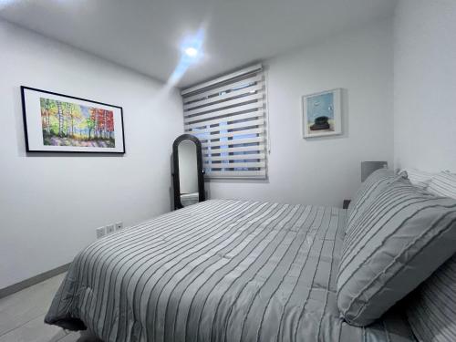 ein weißes Schlafzimmer mit einem Bett und einem Fenster in der Unterkunft ML002 - 2BR - 2BTh in Mexiko-Stadt