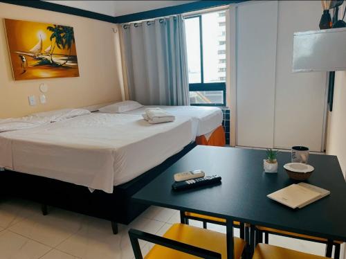 a bedroom with a bed and a desk with a table and chairs at Vista Maravilhosa 706 in Fortaleza