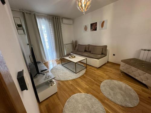 サラエボにあるPrestige Apartman Bulevarのソファとテーブルのあるリビングルーム