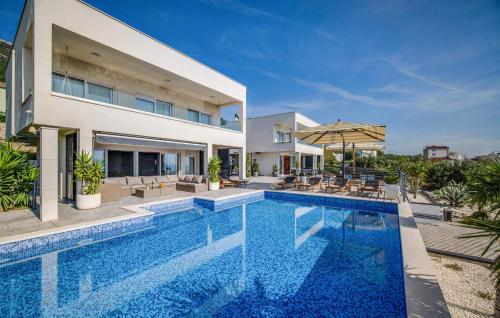 a swimming pool in front of a house at Nice Home In Kastel Stari With Jacuzzi in Kastel Stari