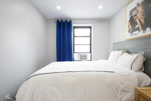 a bedroom with a large white bed with blue curtains at 350-2A Prime gramercy Newly renovated 1BR sleeps 4 in New York