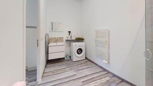 - une buanderie blanche avec lave-linge et sèche-linge dans l'établissement Jolie appartement moderne et cosy, à Vinay