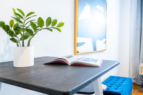a book on a table with a potted plant at 350-GA Spacious Studio Gramercy Sleeps 3 in New York
