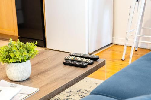 three remote controls sitting on a coffee table in a living room at 350-GA Spacious Studio Gramercy Sleeps 3 in New York